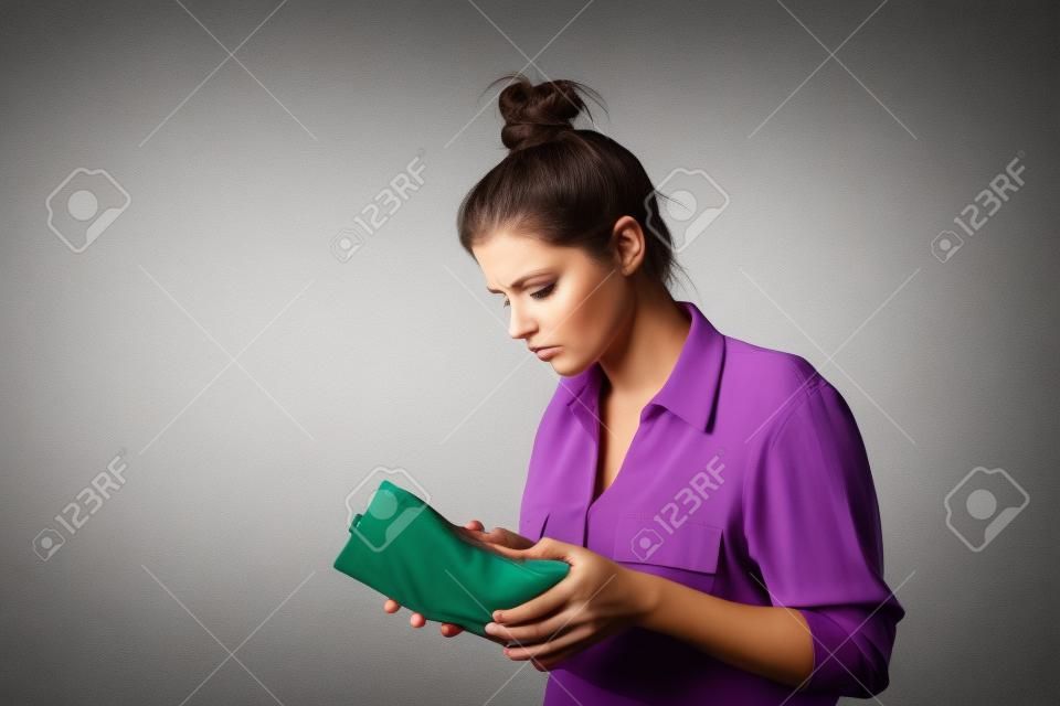 Worried slim woman is looking at an empty wallet