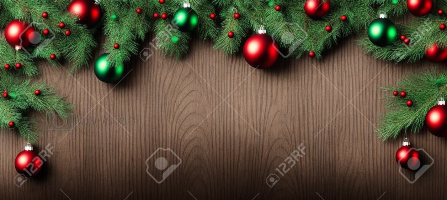 Natale fondo in legno con rami di abete e palle.
