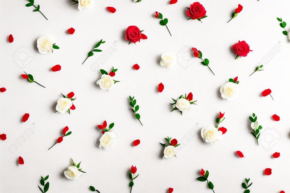 Kwiatowy wzór wykonany z czerwonych i białych pąków kwiatowych róży i gałęzi eukaliptusa na białym tle. gruby układ, widok z góry kompozycja kwiatów.