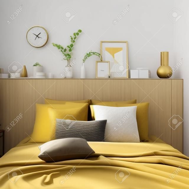 Conceito moderno de design de interiores. Quarto bege brilhante e estilo dourado com cama, travesseiros, cobertura de cama, relógio, ramo de eucalipto, vaso, vela.