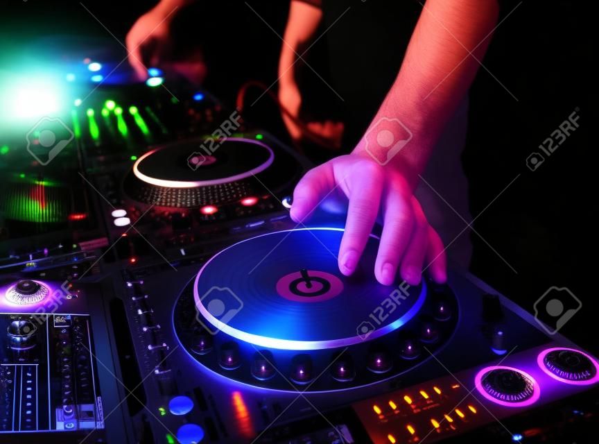 Dj mixes the track in the nightclub at party