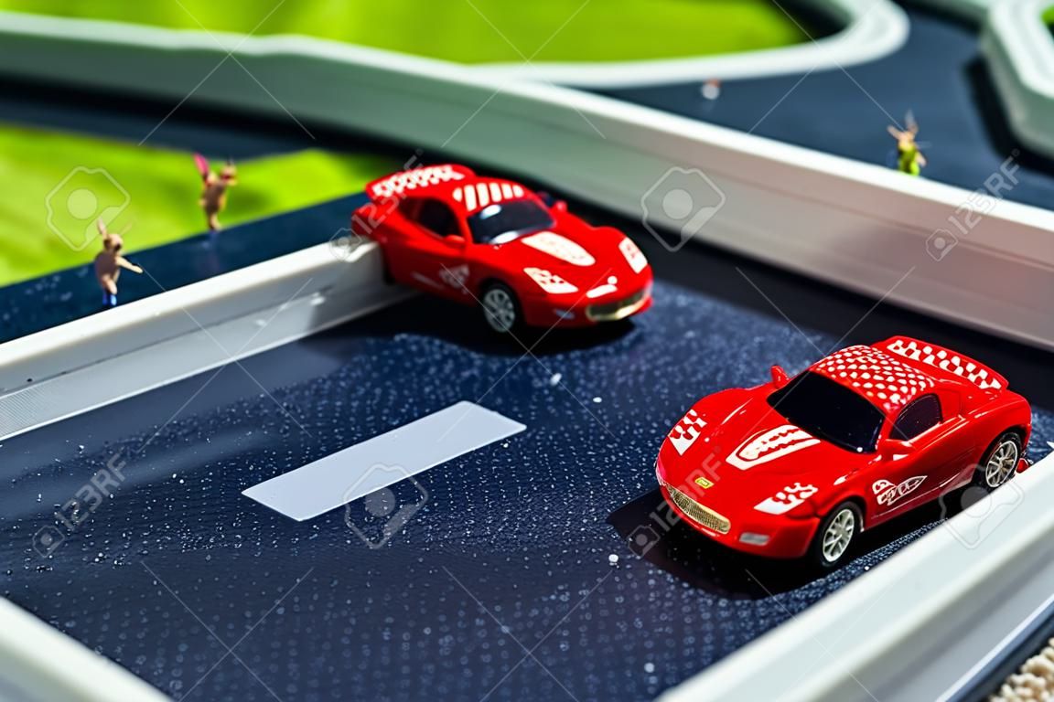 Spielzeug Sportwagen auf einem Steckbrett. Zwei Rot-Rennwagen auf der Rennstrecke