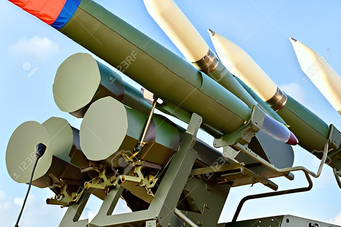 Ballistic missile launcher with four cruise missiles on powerful mobile transportation on background blue sky, antiaircraft forces, military industry. Flag of Russia