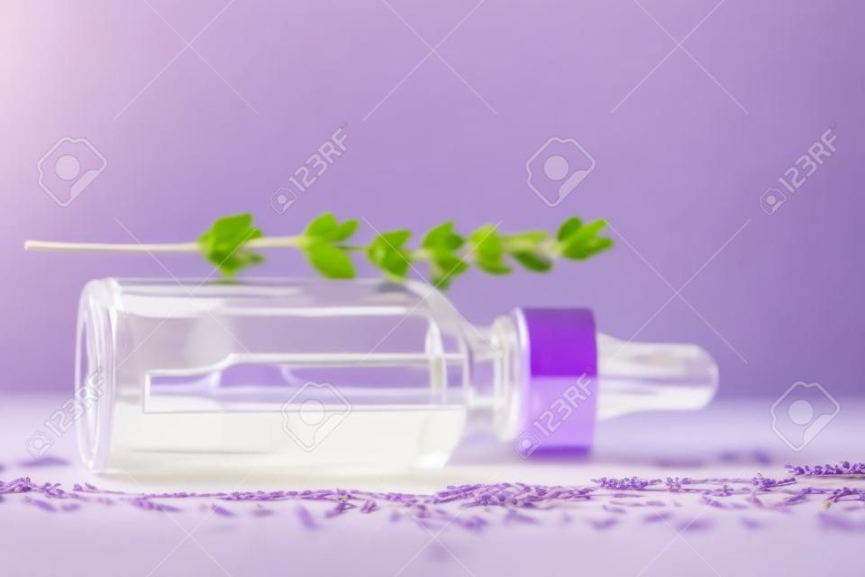 Een fles lavendel cosmetische olie ligt op een houten achtergrond. Een maquette van een cosmetisch product. Conceptueel beeld.