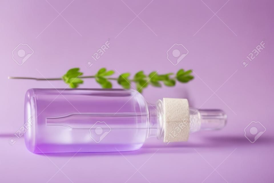 Een fles lavendel cosmetische olie ligt op een houten achtergrond. Een maquette van een cosmetisch product. Conceptueel beeld.