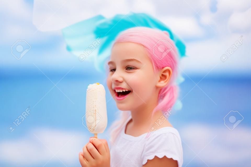 Teenager-Mädchen mit europäischem Aussehen, sieben Jahre alt, isst im Sommer draußen Eis am Stiel