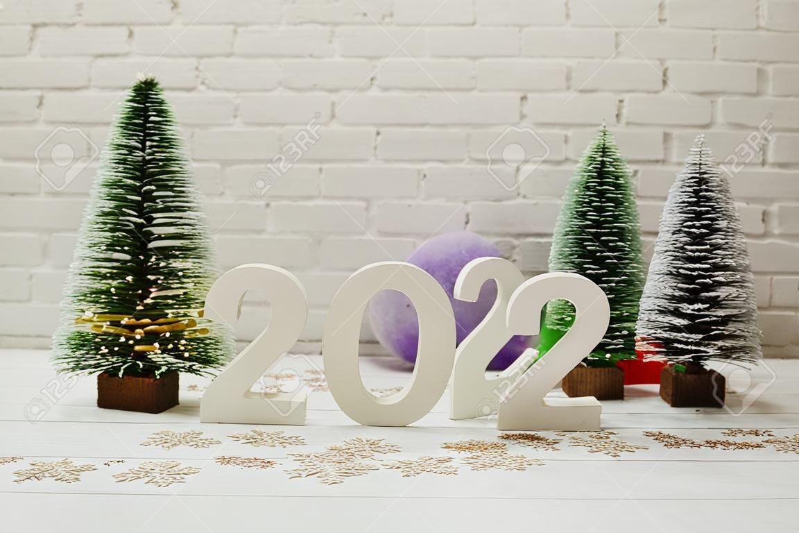 Frohes neues Jahr 2024, festlicher Hintergrund mit Weihnachtsbaum auf weißem Backsteinmauerhintergrund