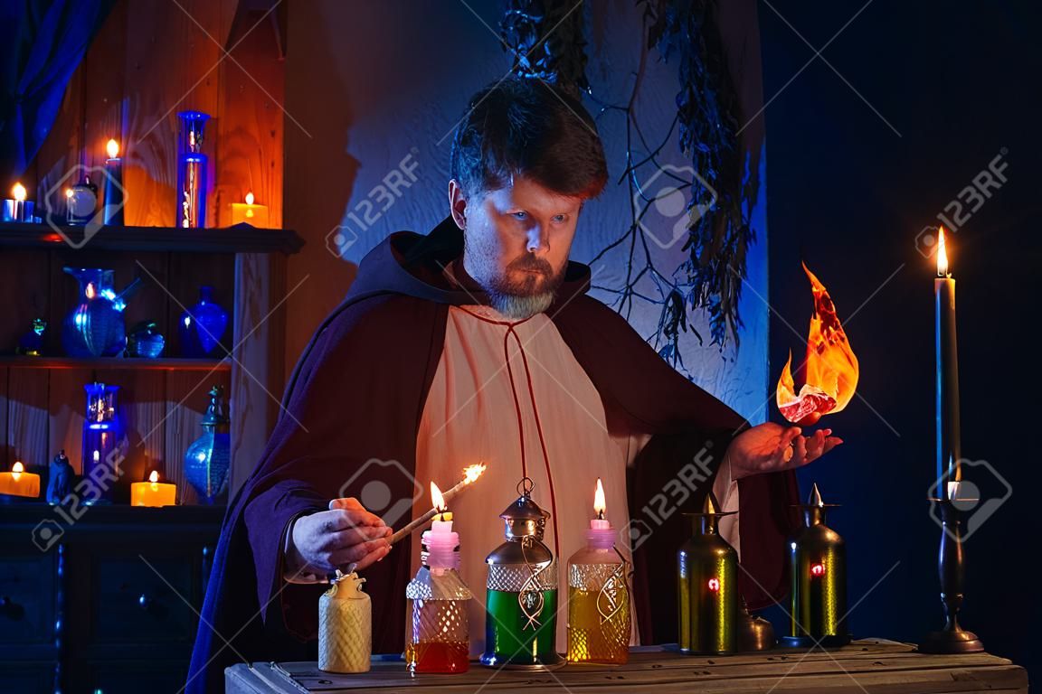 Porträt des Zauberers mit brennenden Kerzen und Zaubertränken