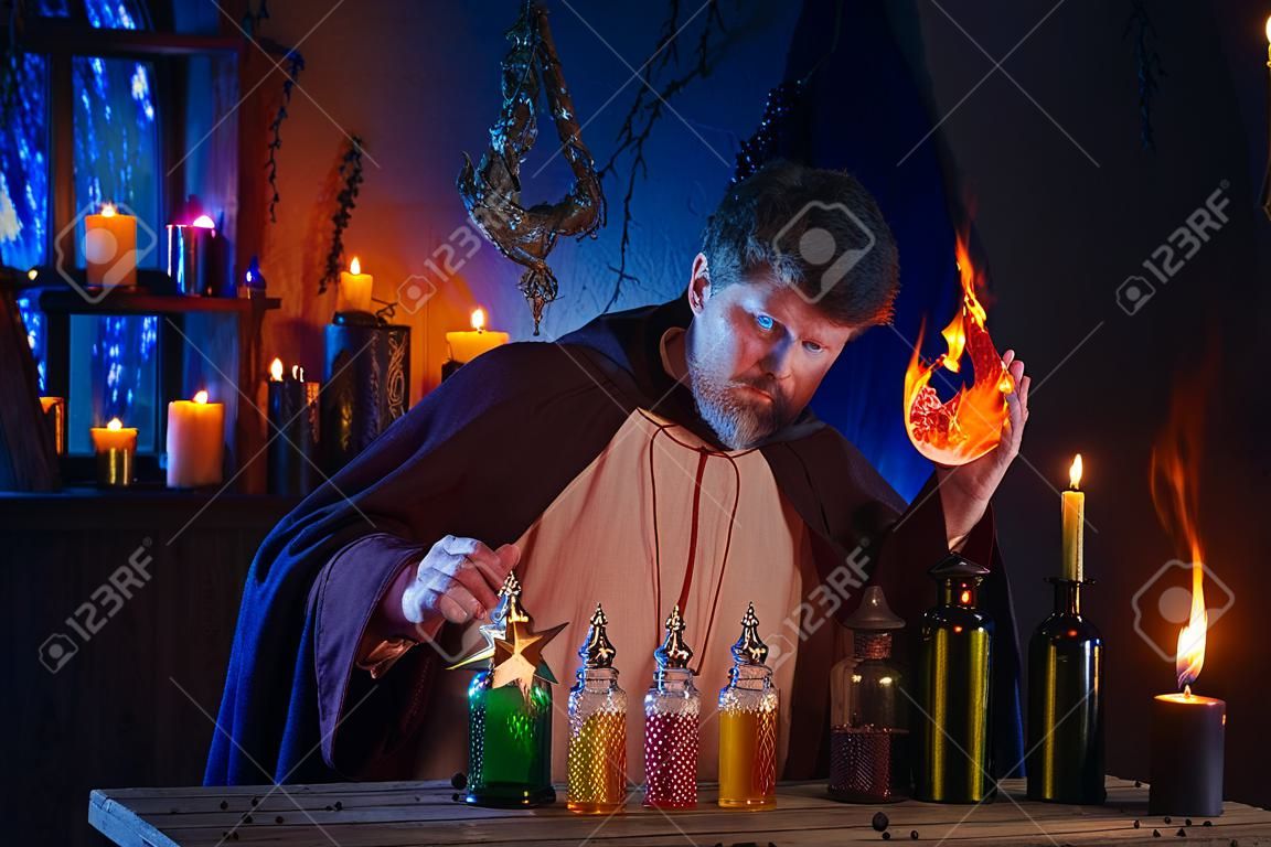 Porträt des Zauberers mit brennenden Kerzen und Zaubertränken