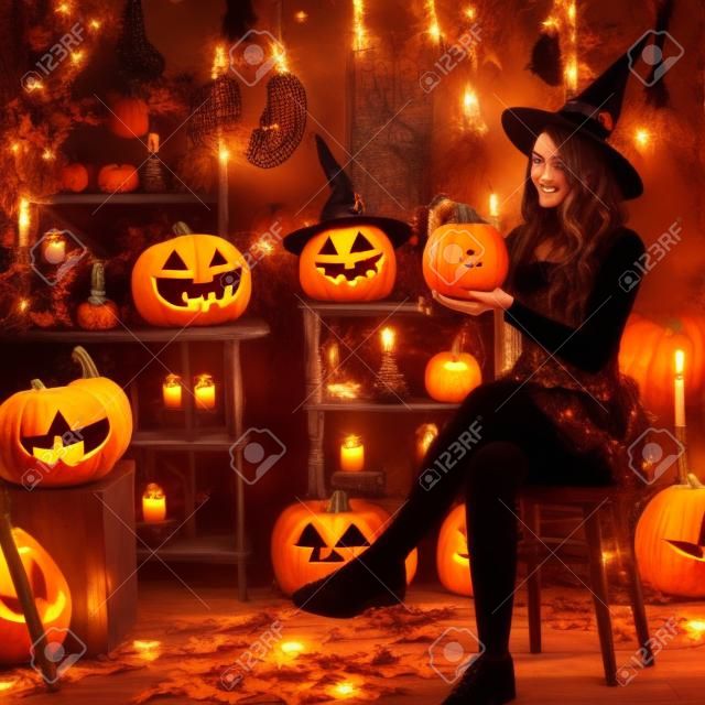 Nastolatka przebrana za wiedźmę z dyniami na tle wystroju na halloween