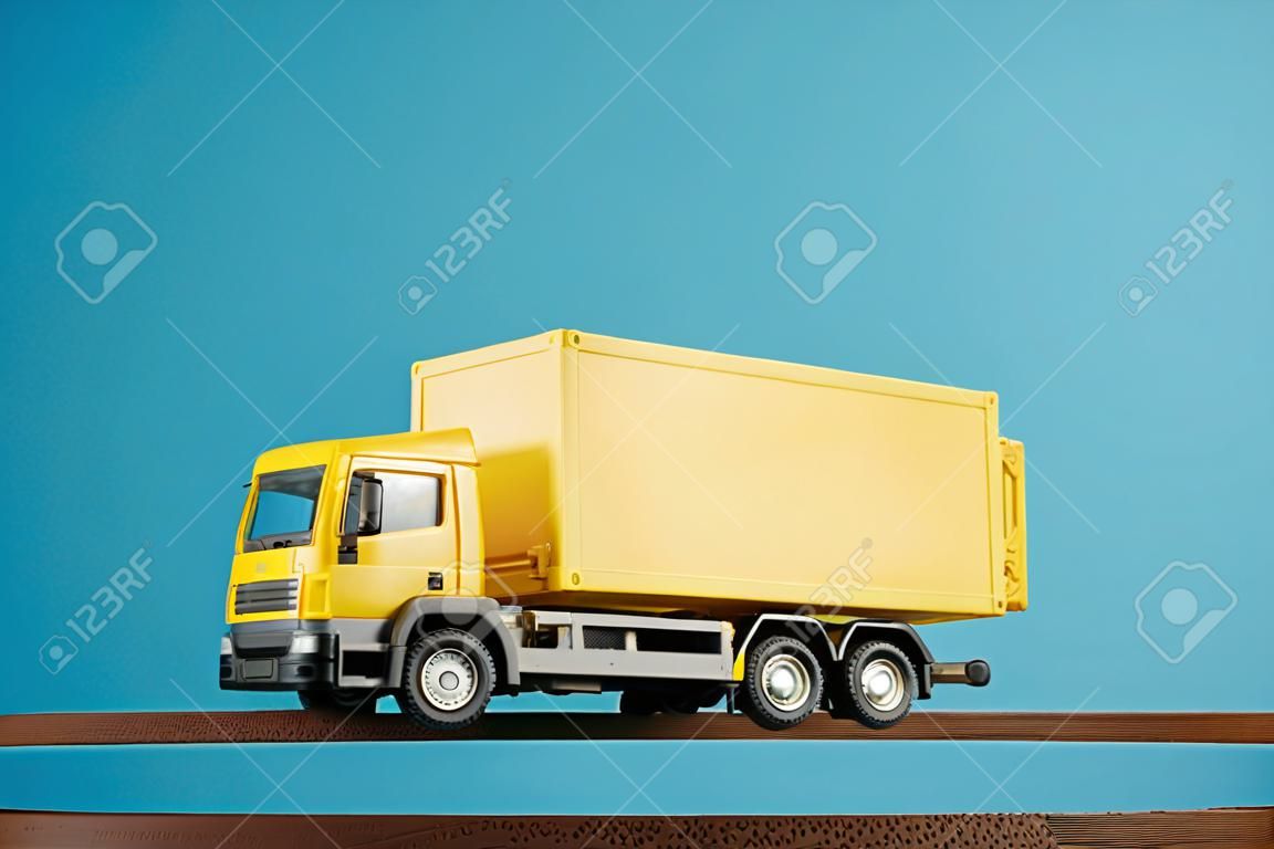 Gelber Containerwagen vor blauem Hintergrund