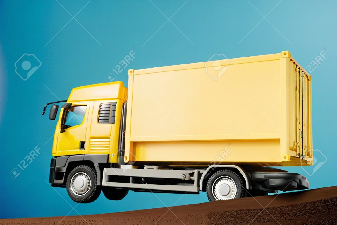 Gelber Containerwagen vor blauem Hintergrund