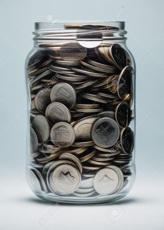 Tarro lleno de monedas aisladas en blanco
