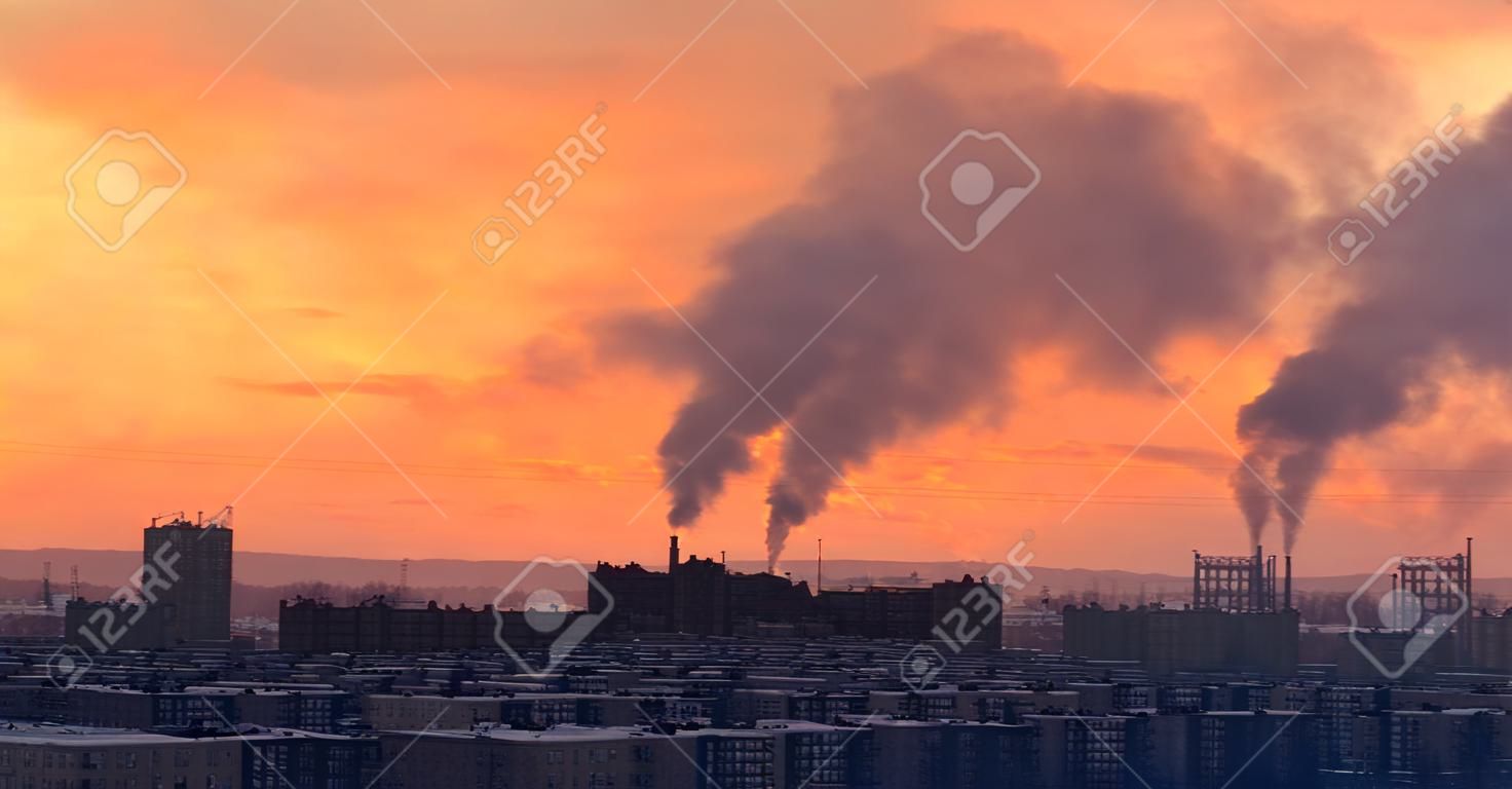 City district on sunset at winter. Industrial plant on background