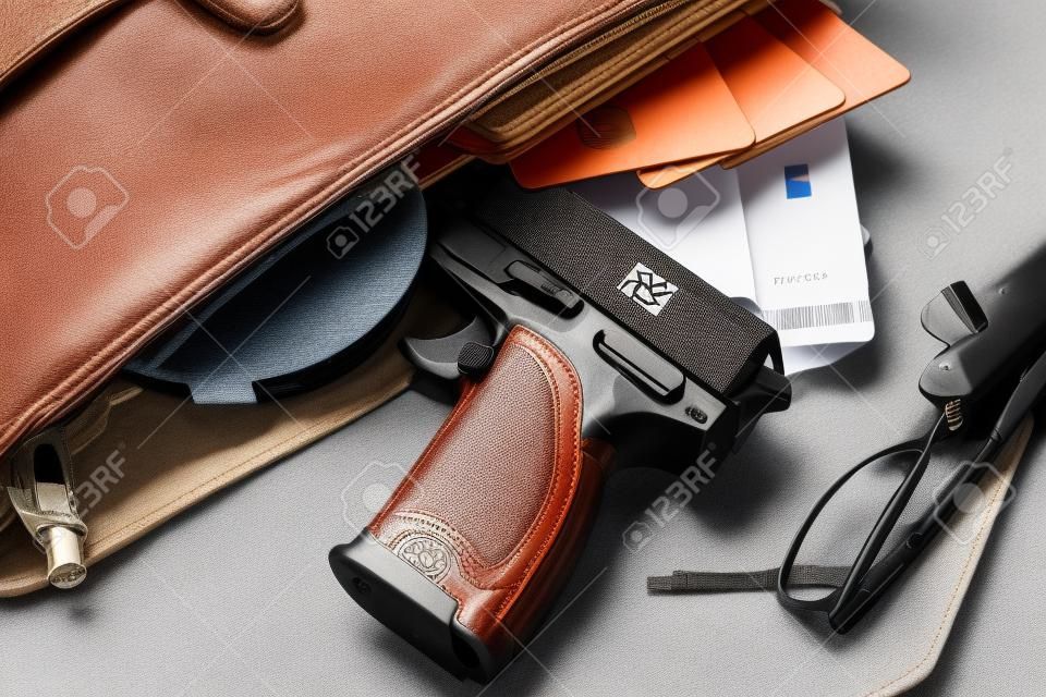 Personalausweis, Reisepass und Pistole in der Frau Tasche