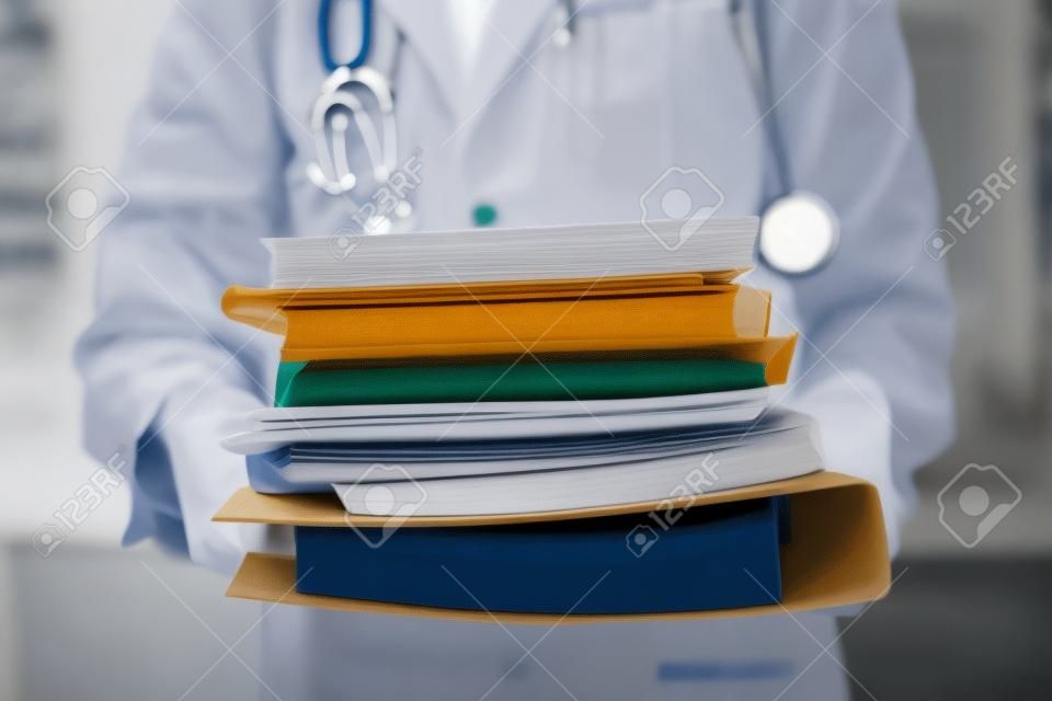 Doctor is holding large stack of folders. Disease history concept