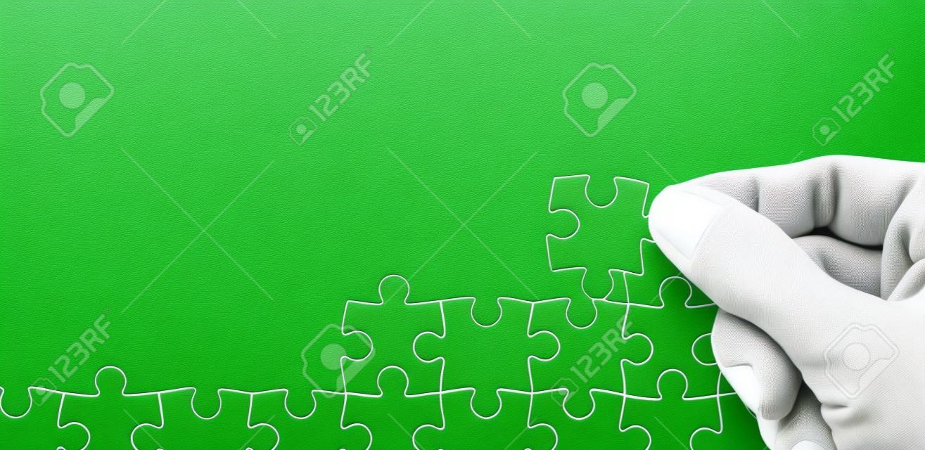 Les Mèches De Main Un Puzzle Blanc Puzzle Sur Le Fond De La Texture Verte.  Photo Avec L & # 39 ; Espace Pour Le Texte Banque D'Images et Photos Libres  De