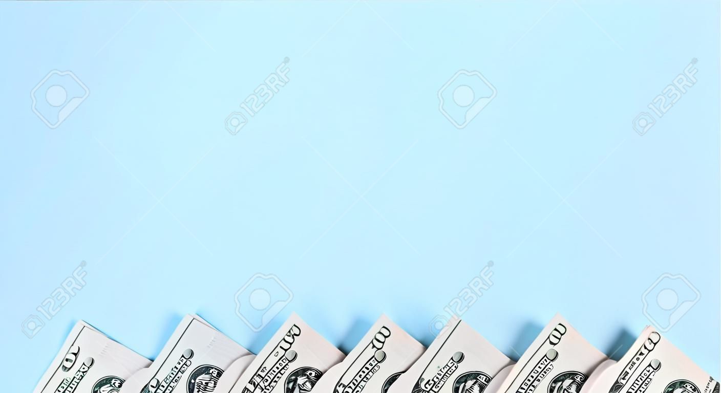 La fila de billetes de un dólar estadounidense de un nuevo diseño se encuentra sobre un fondo azul claro.