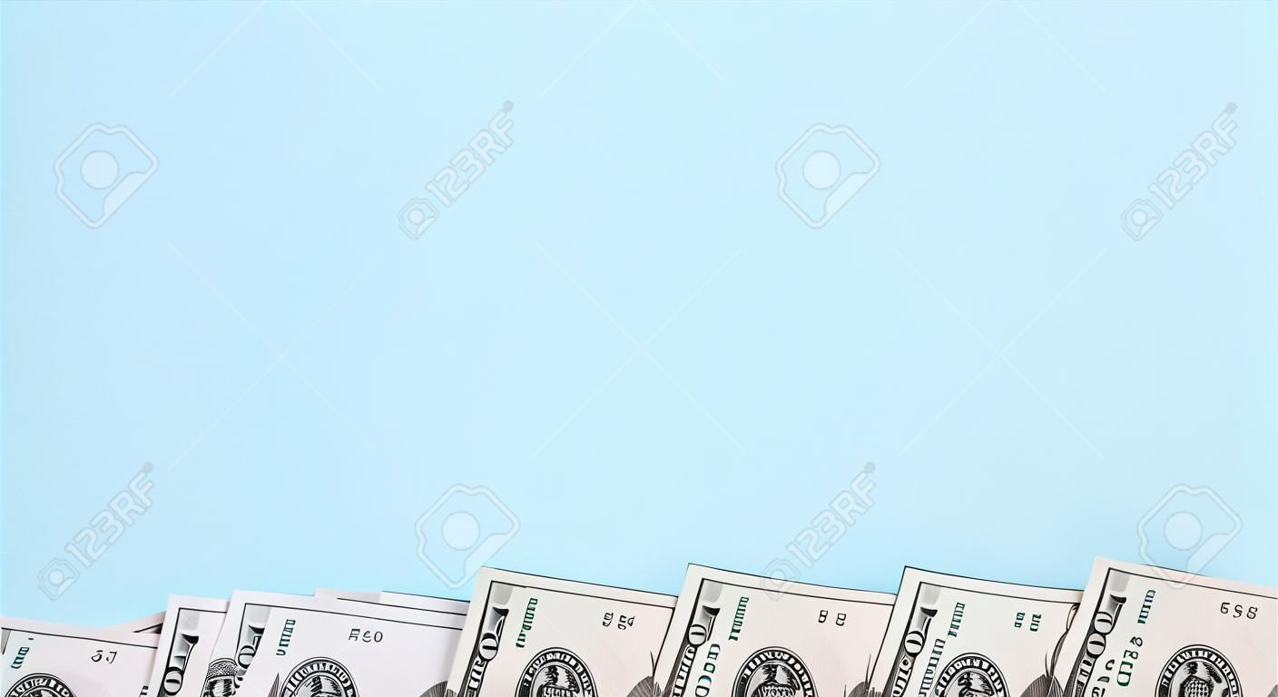 La fila de billetes de un dólar estadounidense de un nuevo diseño se encuentra sobre un fondo azul claro.
