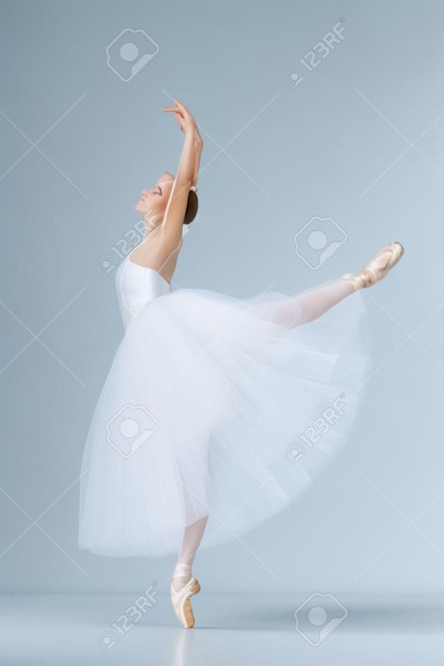 Portret van de klassieke ballerina in witte jurk op blauwe achtergrond