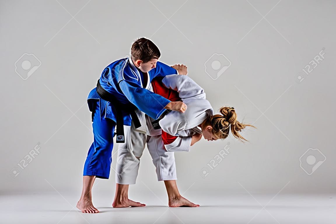 Dwaj wojownicy judoków pozują na szaro