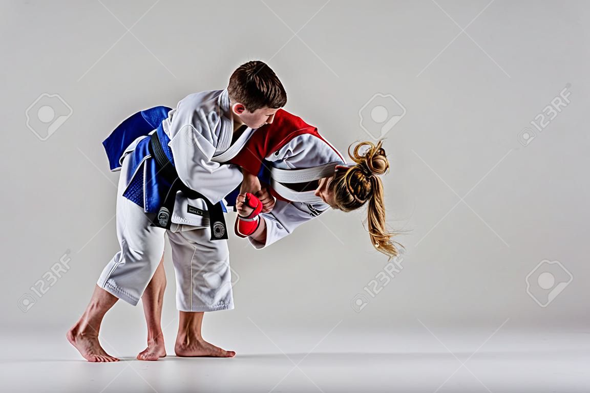 The two judokas fighters posing on gray