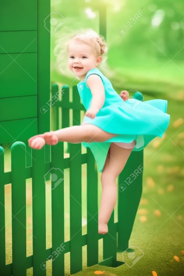 The little girl at playground against park or green forest