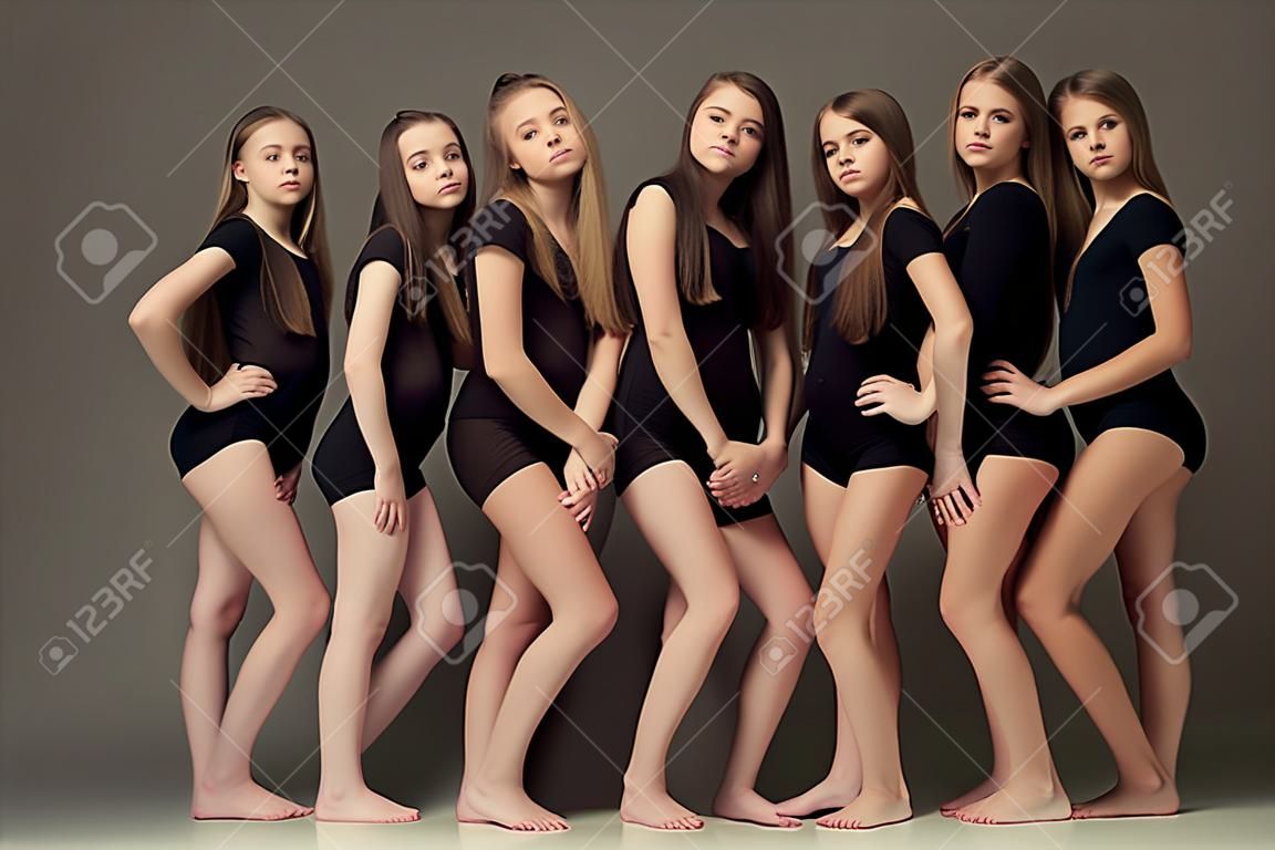 The group of teen girls posing at white studio
