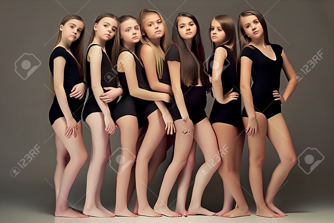 화이트 스튜디오에서 포즈를 취하는 십 대 소녀의 그룹