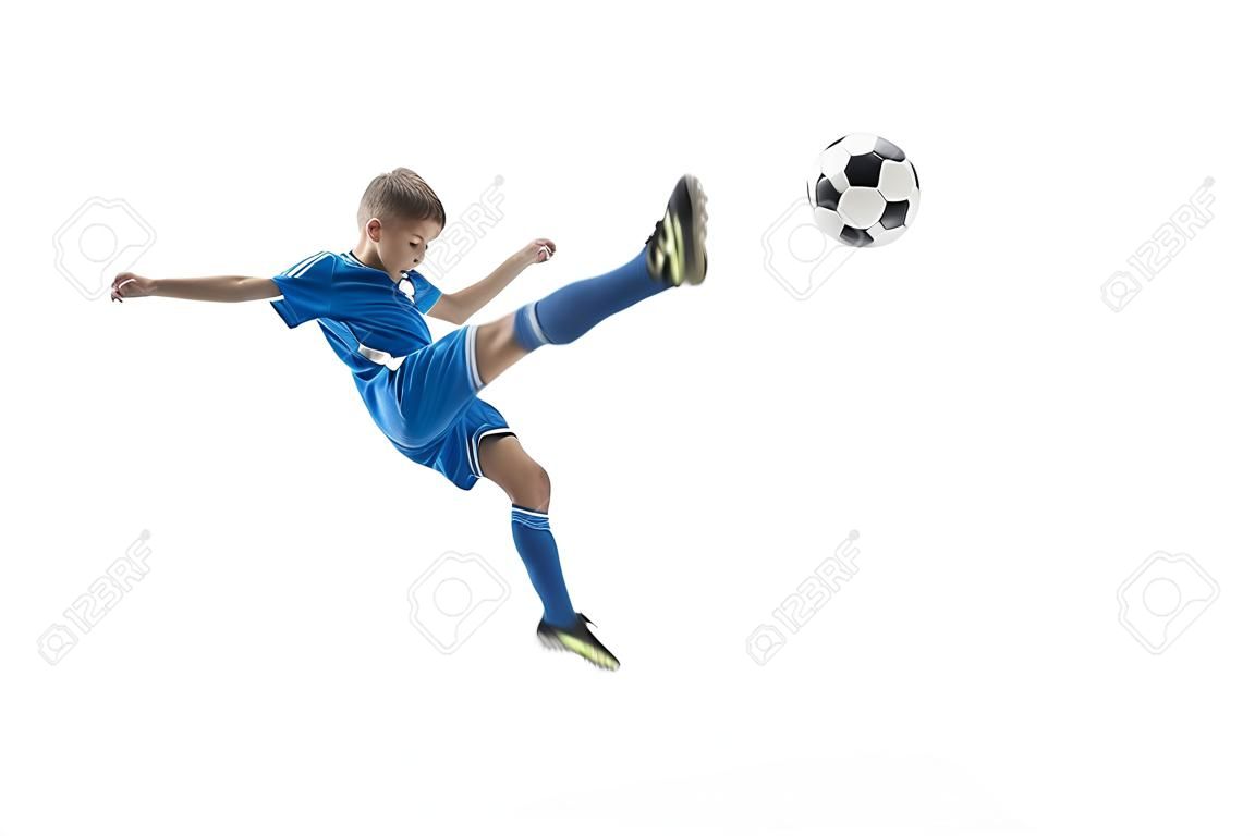 白い上に孤立したフライングキックをしているサッカーボールを持つ若い男の子。スタジオの背景に動いているサッカーのサッカー選手。アクションでジャンプ少年をフィット、ジャンプ、ゲームで動き。
