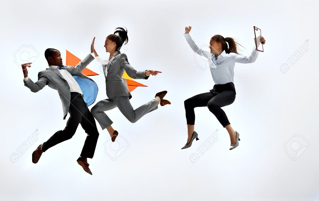Happy businesswoman and african man dancing in motion isolated on white studio background. Flexibility and grace in business. Human emotions concept. Office, success, professional, happiness, expression concepts
