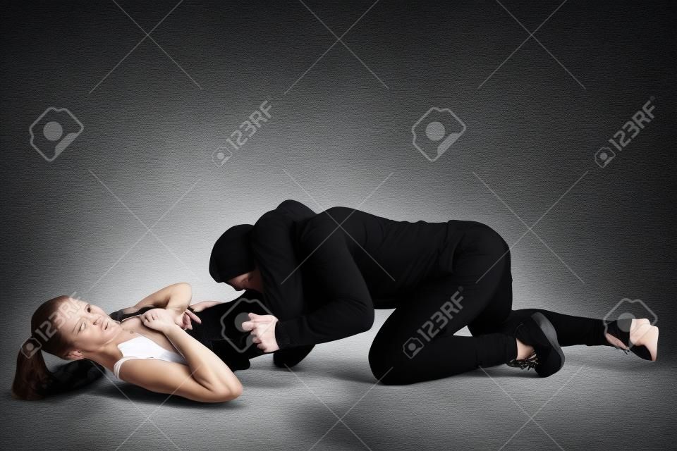 Hombre en traje negro y atlética mujer caucásica peleando sobre fondo blanco de estudio. Autodefensa de las mujeres, derechos, concepto de igualdad. Enfrentar la violencia doméstica o el robo en la calle.