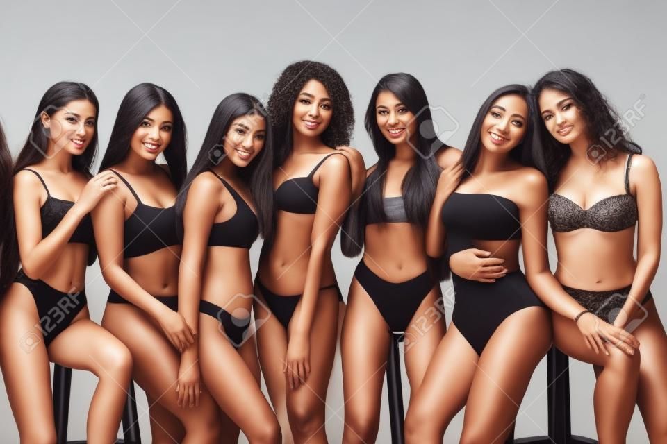 Grupo de mulheres com corpo e etnia diferentes posando juntos para mostrar o poder e a força da mulher. Tipo curvo e magro do conceito de corpo feminino. Meninas bonitas, beleza natural, auto-aceitação.