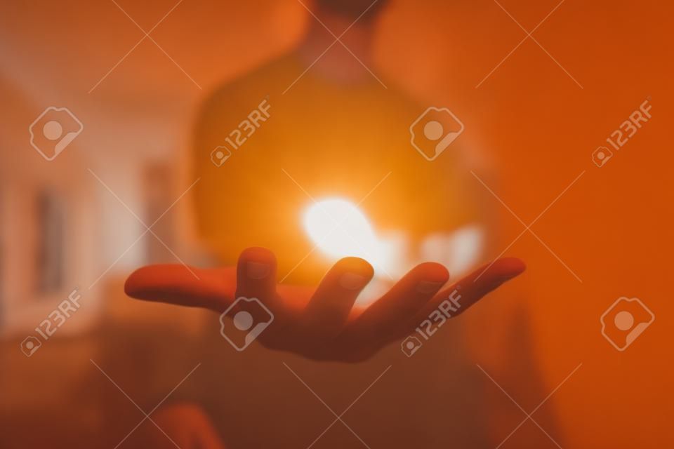 Homem segurando a mão e mostrando algo em uma sala brilhante