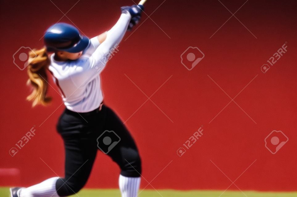 Een vrouwelijke honkbalspeler is bij Bat klaar voor de Pitch