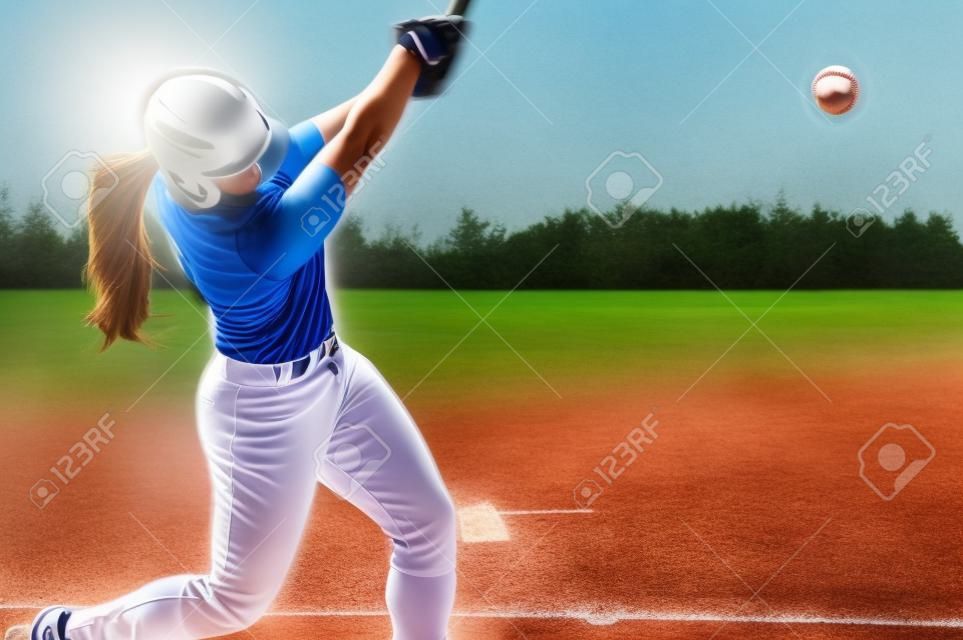 Una giocatrice di baseball sta battendo oscillando al campo