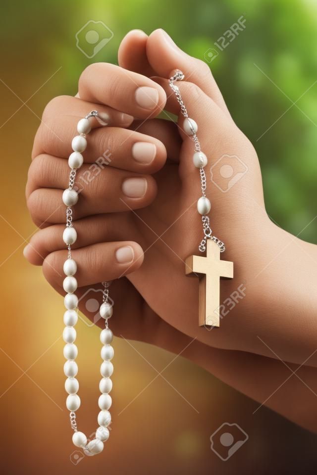 Христианская человека молиться с четками в руках