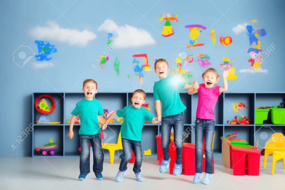 niños de edad preescolares saltando en el aula