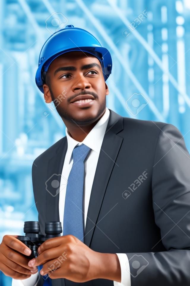 handsome afro american petrochemical businessman with binoculars at plant