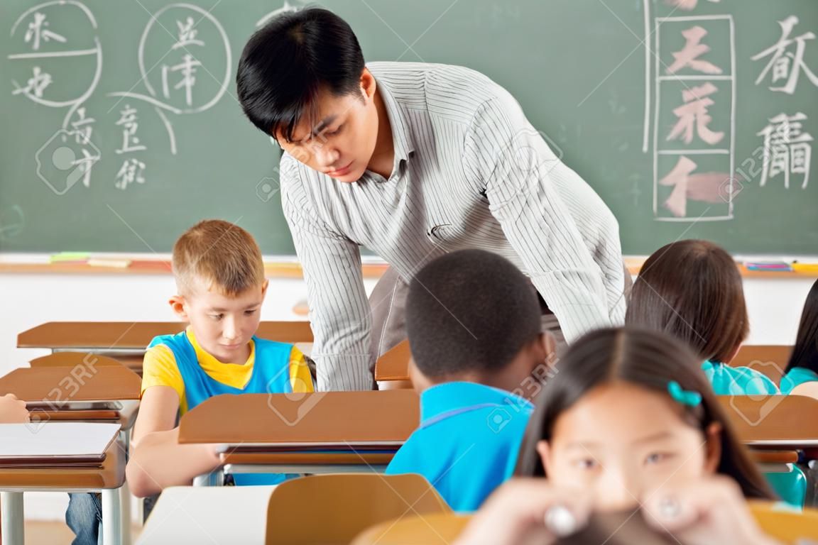 profesor de lengua china masculina en el aula con un grupo de estudiantes de primaria