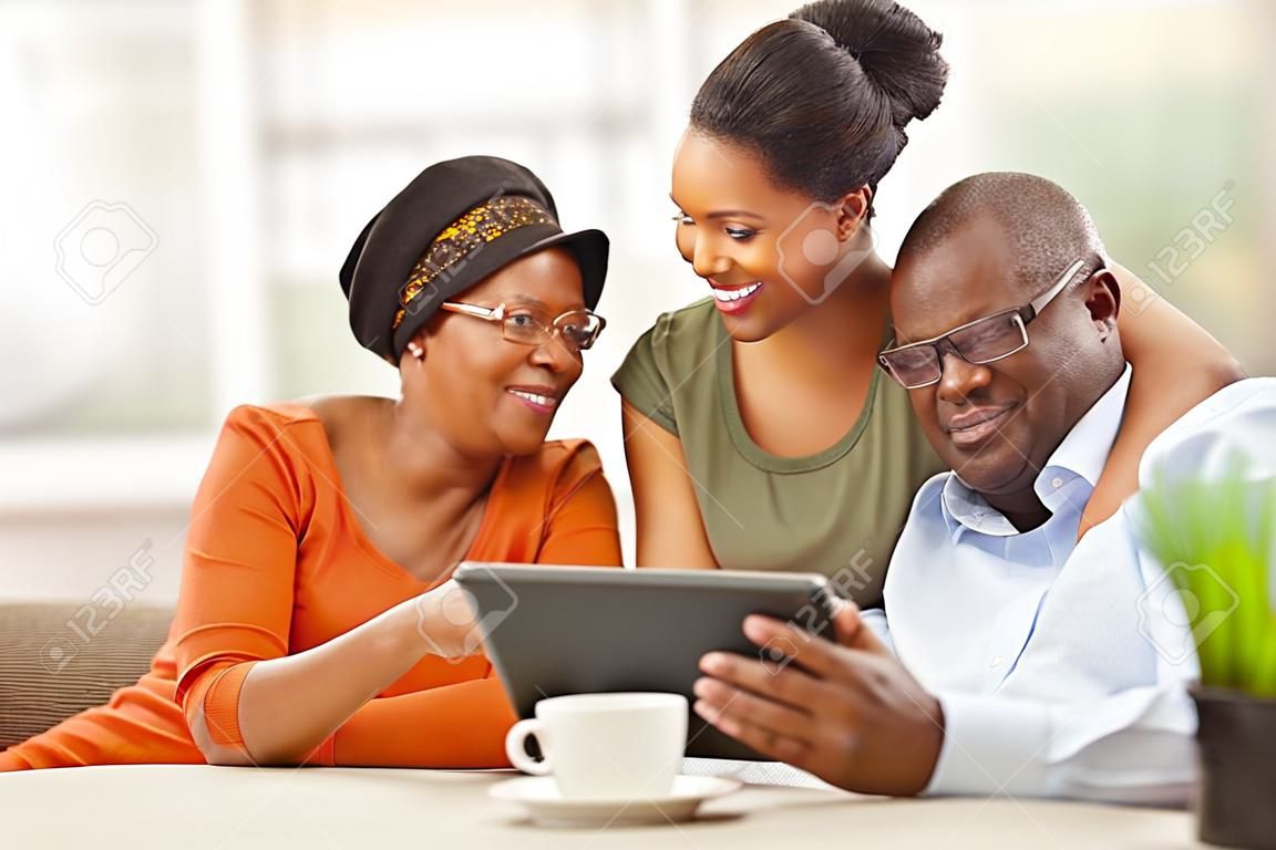 fröhlichen afrikanischen Familie zu Hause mit Tablet-PC