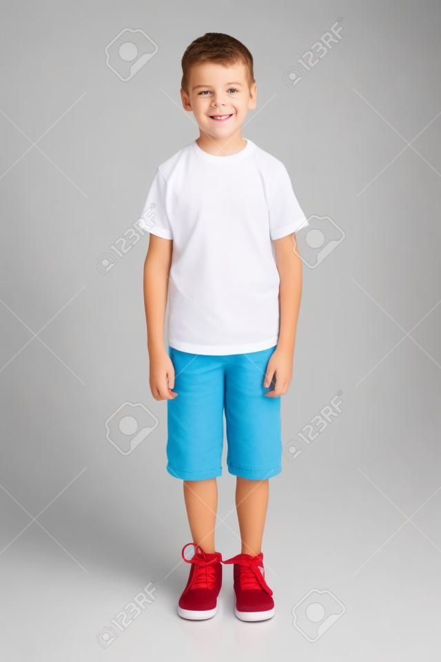 śliczny chłopiec stojący na białym tle