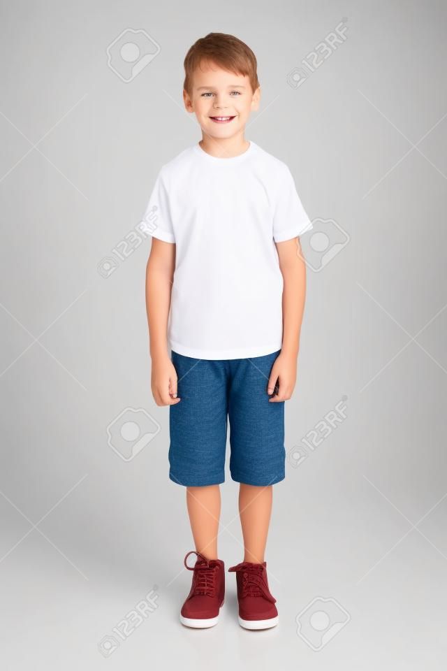 śliczny chłopiec stojący na białym tle