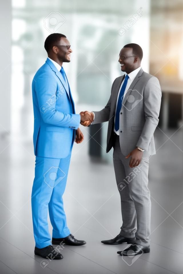 successful african businessmen handshaking in conference hall