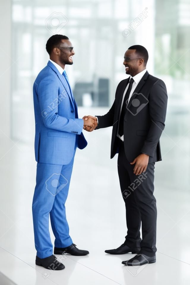 successful african businessmen handshaking in conference hall