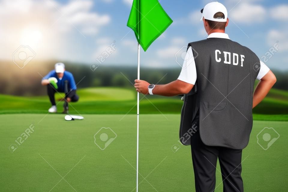 Golf - caddy holding flag, golfer reading green