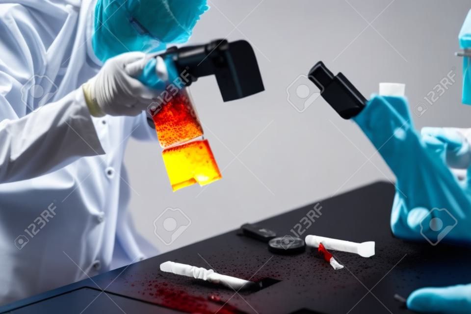 Forensische Wissenschaft im Labor. Forensischer Wissenschaftler, der Messer mit Blutbeweisen fotografiert