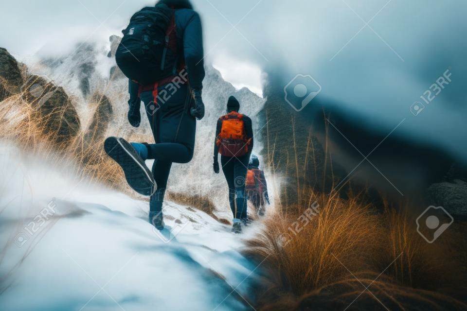 Grupo de caminhantes que andam nas montanhas. As bordas da imagem são borradas