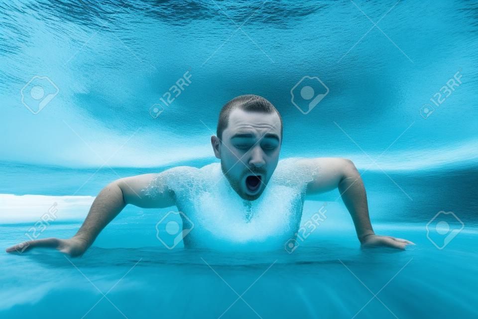 L'homme nage dans le trou de la glace avec le visage émotionnel