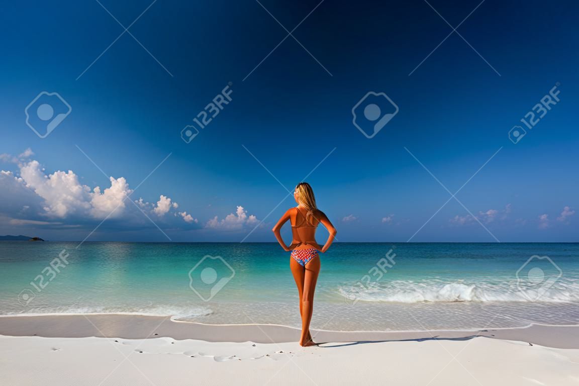 Junge Frau auf einem weißen Sandstrand stehen